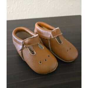 Brown leather Starbie baby moccasins with a T-strap design